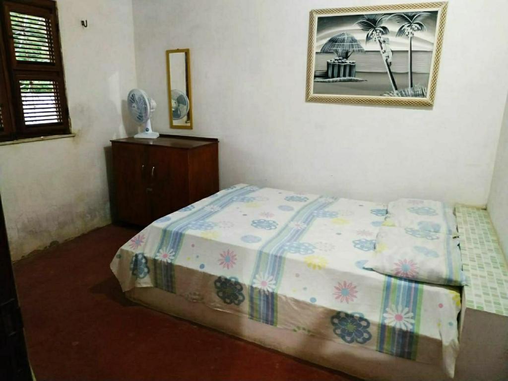 a bedroom with a bed and a picture on the wall at Baleia Beach - Casa de Praia in Itapipoca