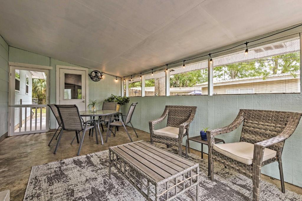 a screened porch with chairs and a table and a tableablish at Ocean Springs Getaway - Walk to Beach and Downtown! in Ocean Springs
