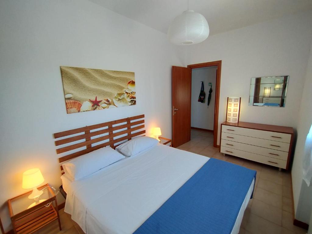 een slaapkamer met een groot wit bed met blauwe lakens bij Stella Marina in Montesilvano