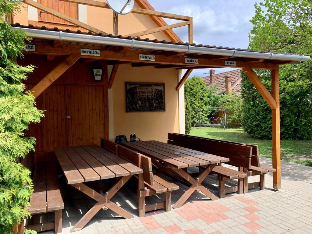 - une table de pique-nique en bois et des bancs sous un pavillon dans l'établissement Mátrai Vadászház 2, à Mátraterenye