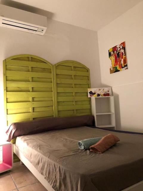a bedroom with a large bed with a green headboard at U riposu in Bastia