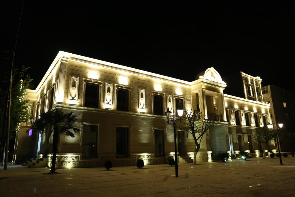 a building lit up at night with lights at Luxe Lankaran Hotel in Lankaran