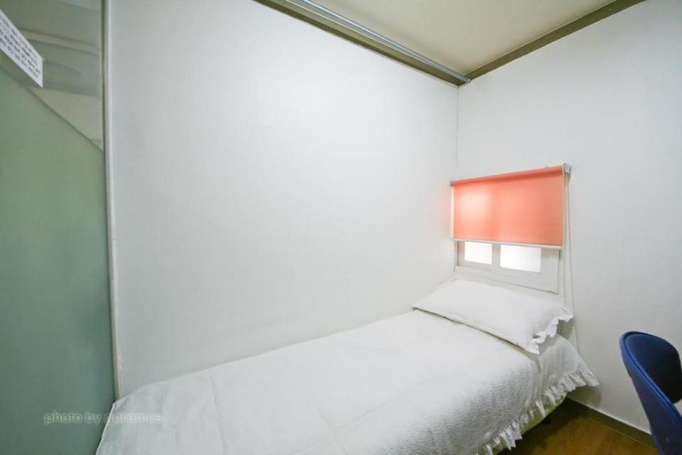 een slaapkamer met een wit bed en een raam bij Rodemhouse in Seoul