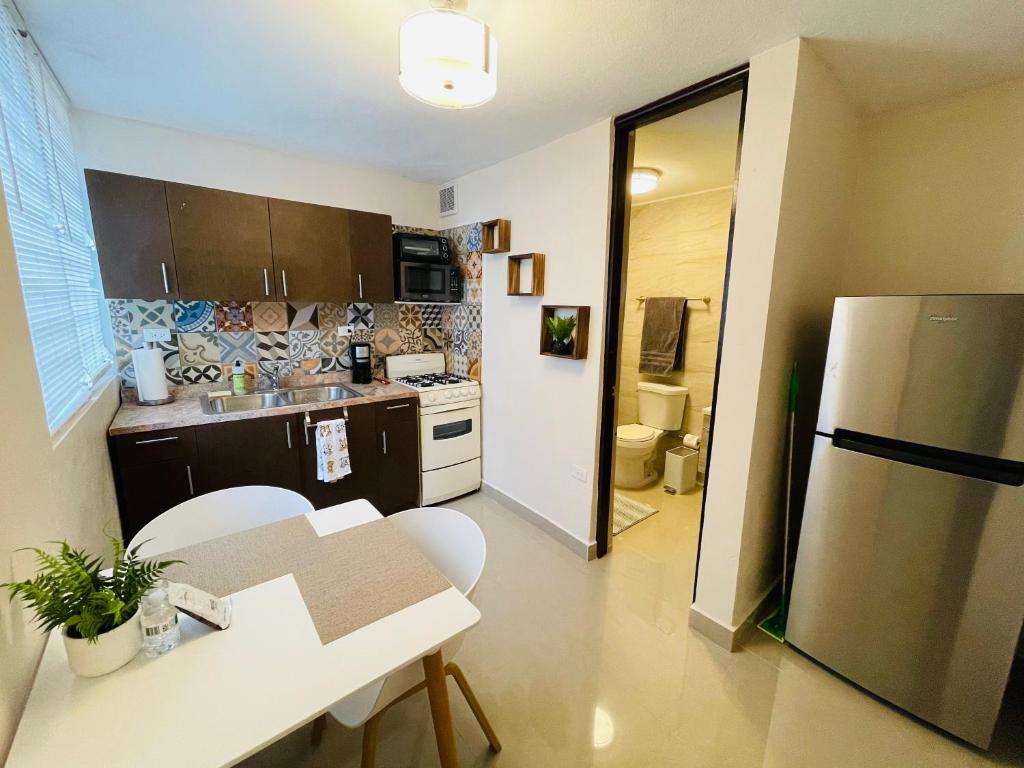 a small kitchen with a table and a refrigerator at Private Patio Retreat with Zen Vibe in Ponce
