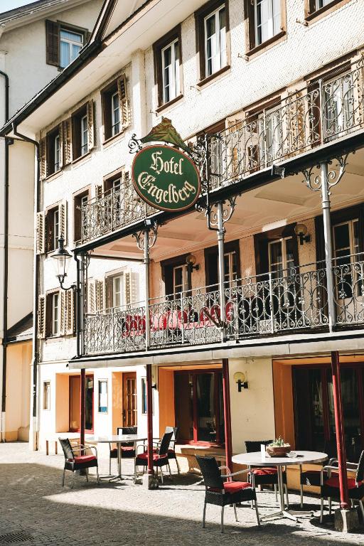a building with tables and chairs in front of it at Hotel Engelberg "mein Trail Hotel" in Engelberg