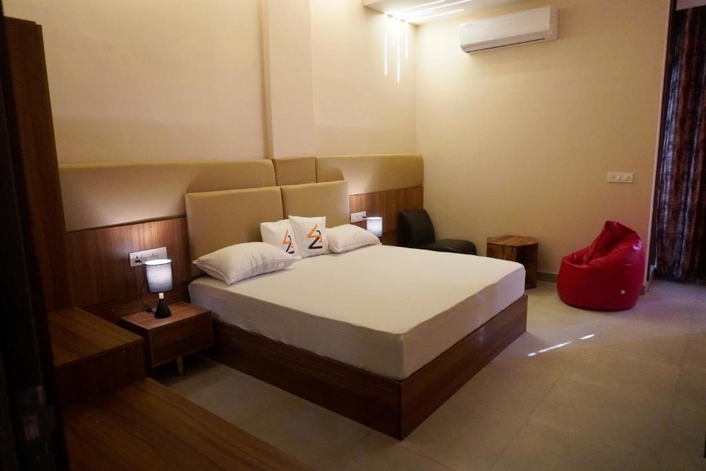 a bedroom with a bed with a red bag on it at Era hotel in Ambāla