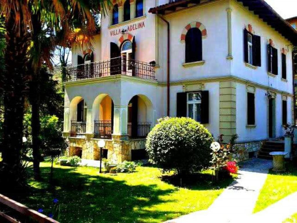 a large white house with a balcony on top of it at Apartman Villa Adelina in Lovran