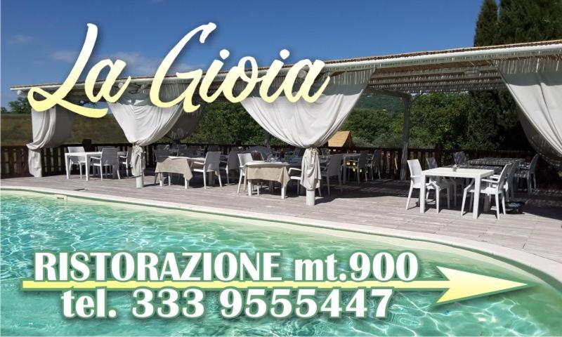 een bord voor een restaurant naast een zwembad bij Agriturismo la Gioia in Scansano