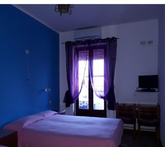 um quarto azul com uma cama e uma janela em Hotel Torre em Vulcano