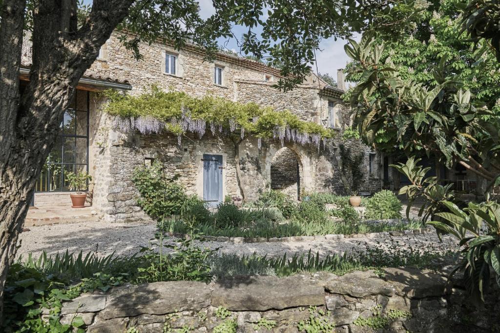 una casa de piedra con un jardín delante de ella en La Cour du Marronnier, en Pont-de-Barret