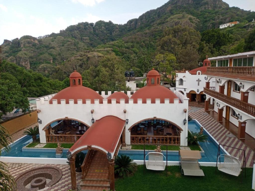 a building with a pool and mountains in the background at Hotel Leyenda del Tepozteco in Tepoztlán