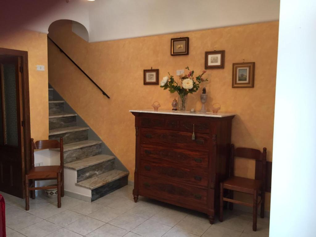 una habitación con una escalera y un tocador con un jarrón de flores en casa MARINO, en Caltabellotta