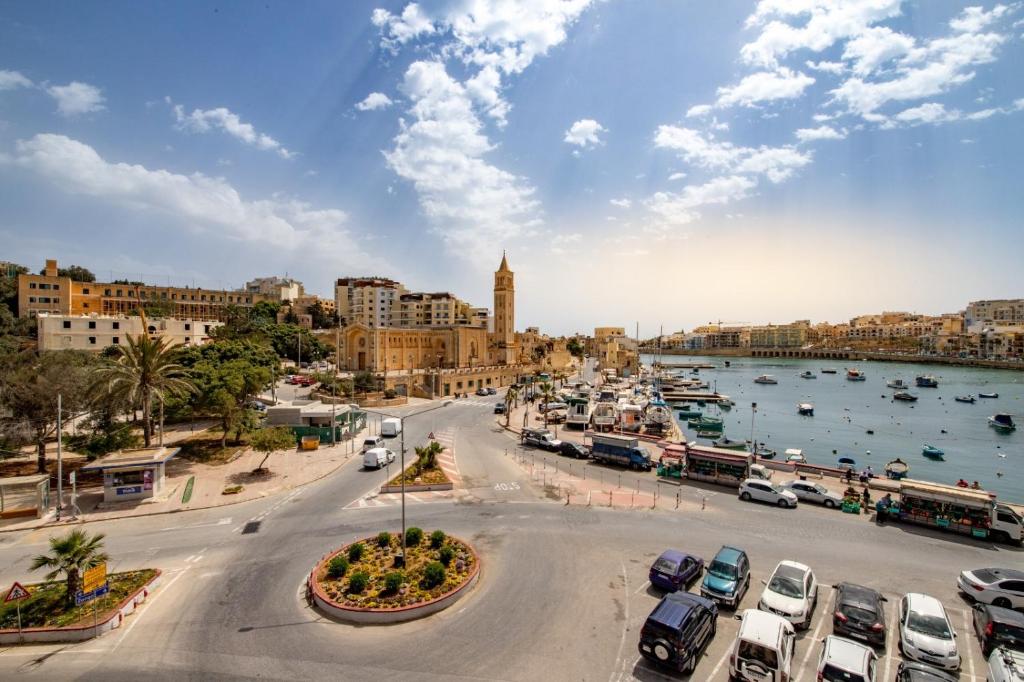 a city with cars parked in a parking lot at Skalina in Marsaskala