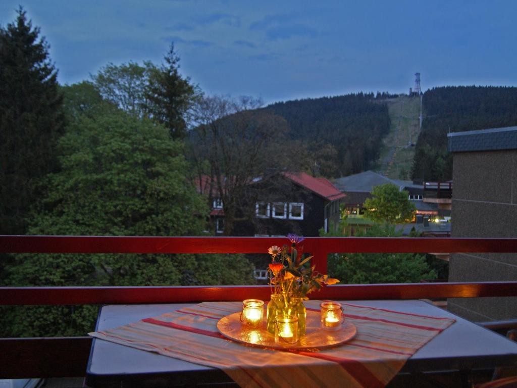 a table with candles and flowers on a balcony at Bergblick471 in Hahnenklee-Bockswiese