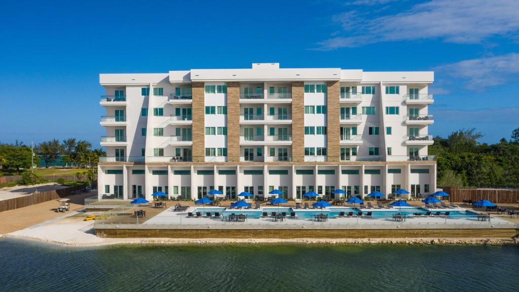 a large hotel with a pool and umbrellas and chairs at Sunset Caribe Belize in San Pedro