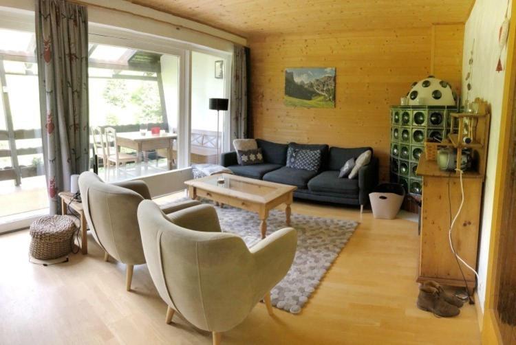 - un salon avec un canapé, des chaises et une table dans l'établissement Comfortable chalet Sankt Oswald, à Sankt Oswald