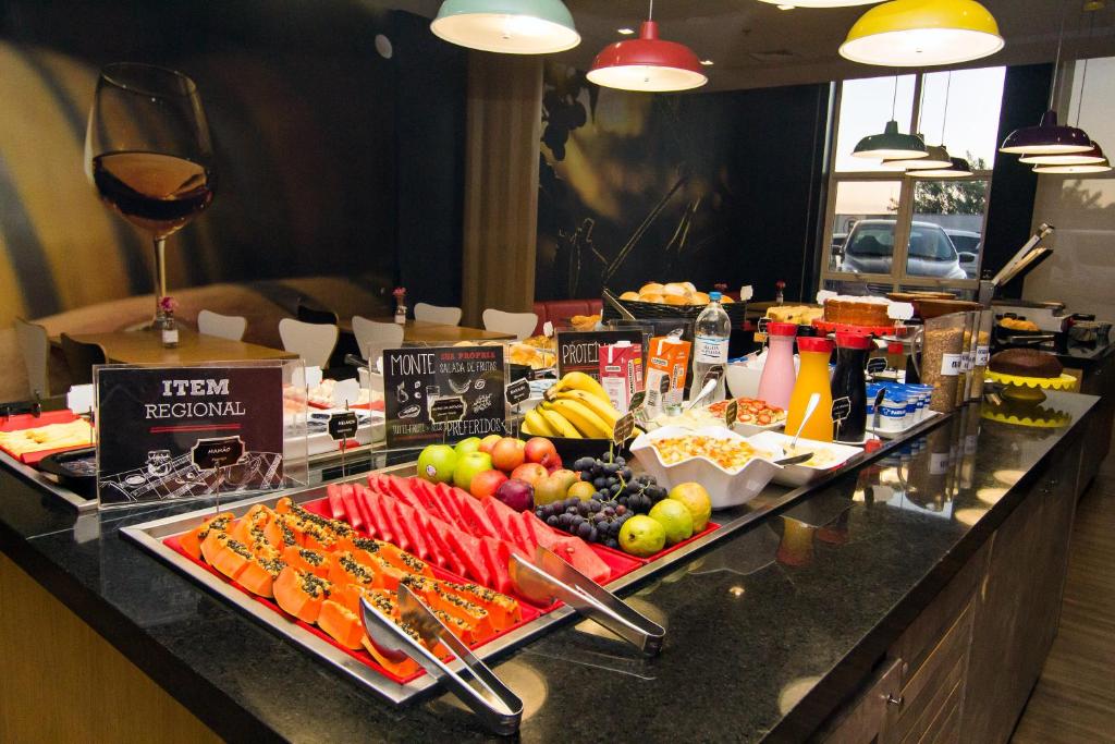 un buffet con frutas y verduras en un mostrador en ibis Caxias do Sul en Caxias do Sul