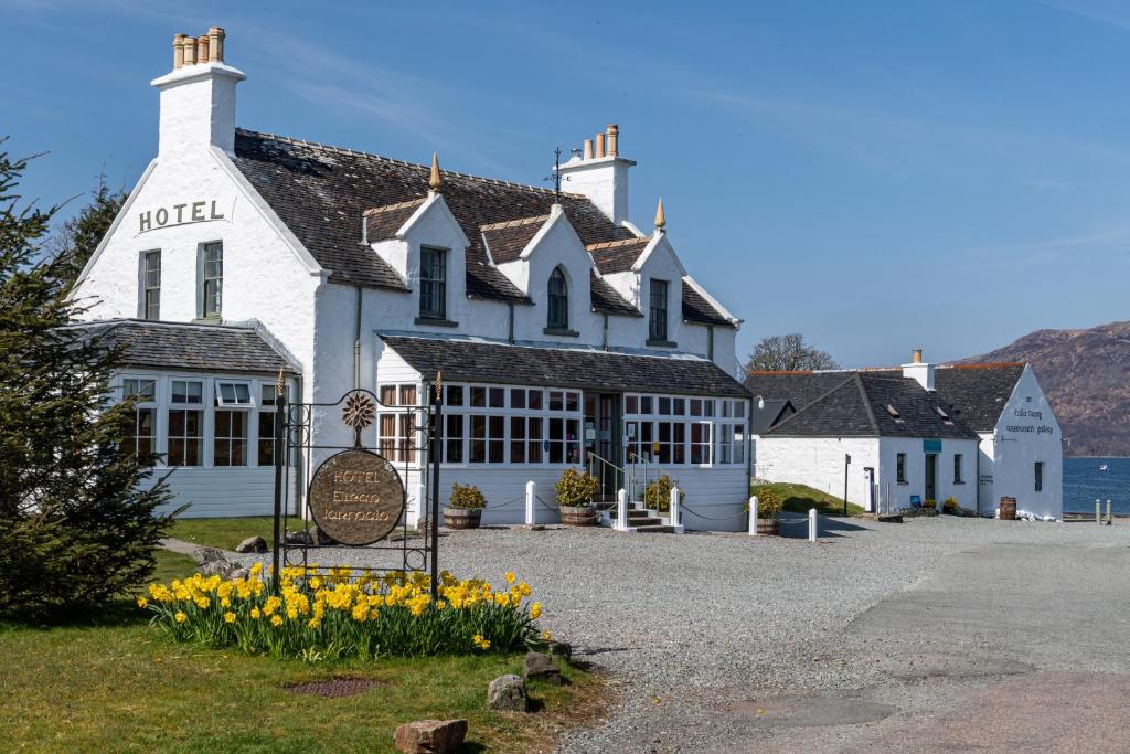 un edificio blanco con flores amarillas delante de él en Hotel Eilean Iarmain, en Isleornsay