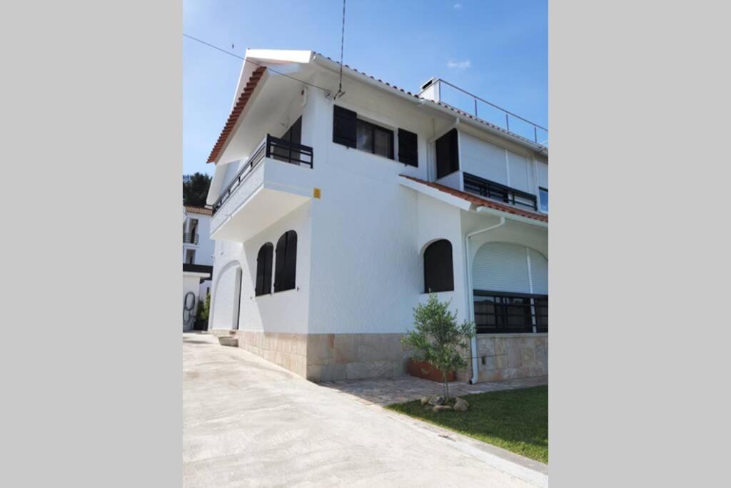 a white house with a balcony on a street at ALOJAMENTO -GUEST HOUSE - Caparica - Trafaria - Surf Sun and Lisbon Lovers in Trafaria