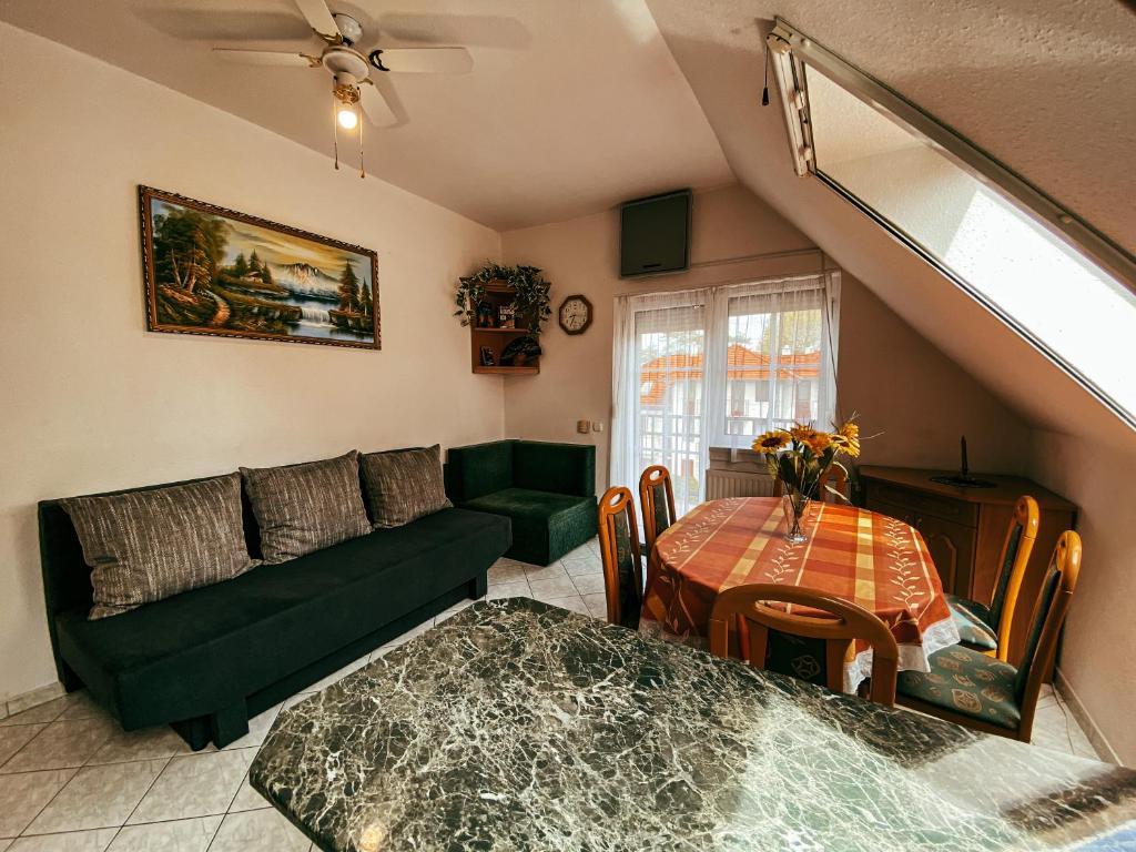 ein Wohnzimmer mit einem Sofa und einem Tisch in der Unterkunft Casa Fiore By BLTN Balatonlelle in Balatonlelle