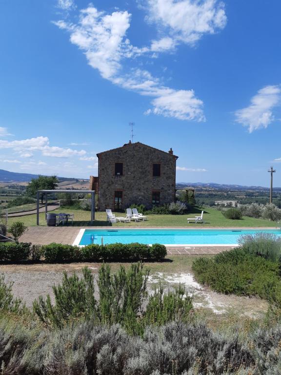 a house with a pool in front of a building at Podere Erba appartamento con piscina in Cinigiano