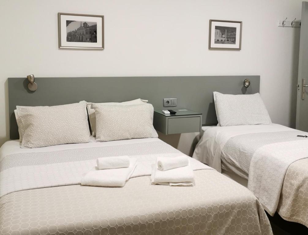 een kamer met 2 bedden en handdoeken erop bij Flor da Primavera - Residencial e Apartamentos in Azambuja