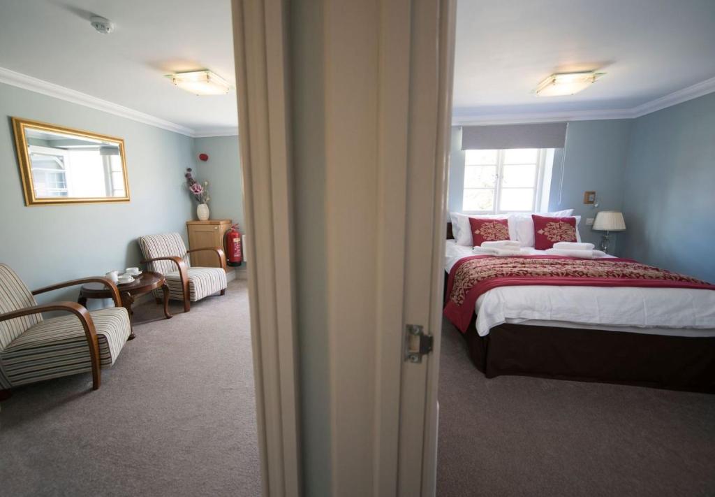 a bedroom with a bed with red pillows at East Walls Hotel in Chichester