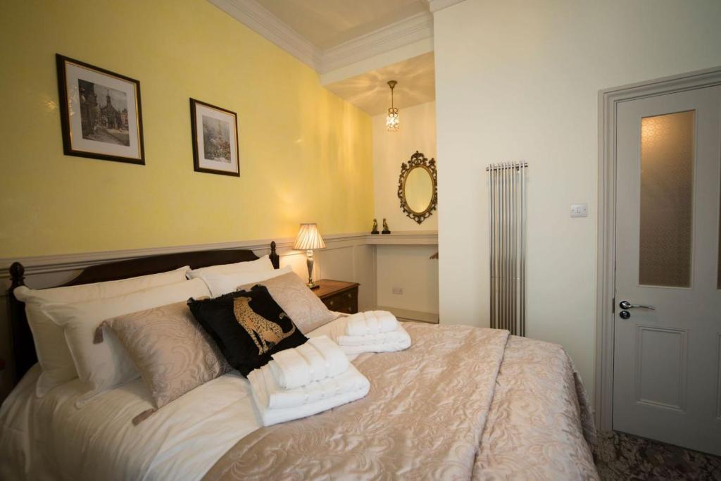 a bedroom with a bed with towels on it at East Walls Hotel in Chichester