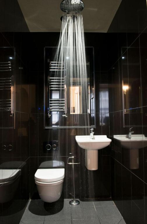 a bathroom with a toilet and a sink and a mirror at East Walls Hotel in Chichester