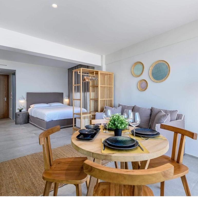 salon ze stołem i łóżkiem w obiekcie NOA BEACHFRONT SUITES w Kardamenie