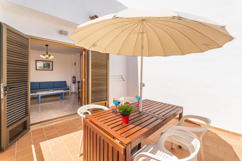 a wooden table and chairs with an umbrella at Apartamentos Karin 1ºB in Felanitx