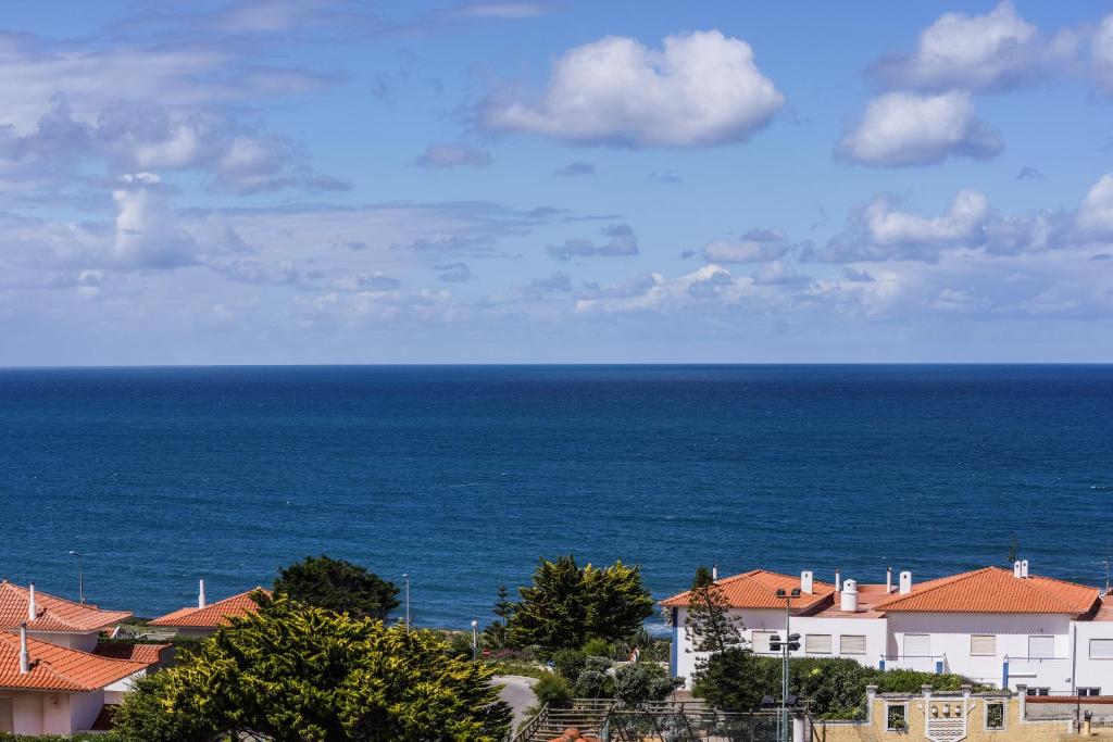 a view of the ocean with houses and buildings at Ericeira Panoramic Sea View Apartments in Ericeira