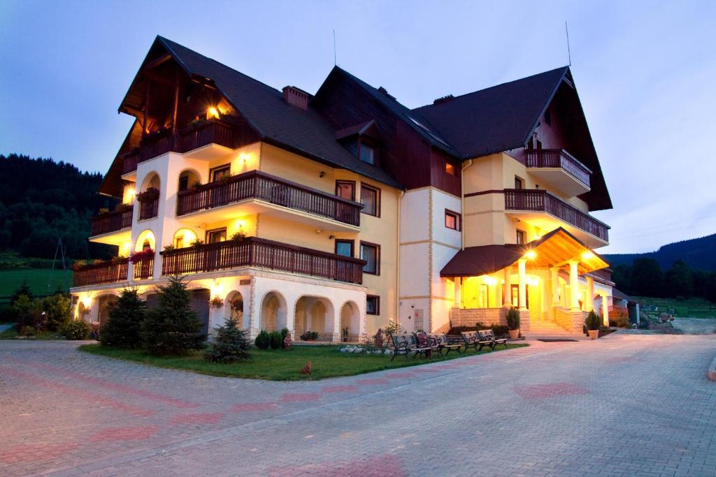 a large building with lights on the side of it at Gościniec Willa Sandra in Stronie Śląskie