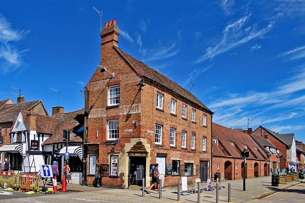 um grande edifício de tijolos numa rua da cidade em Penthouse On Waterside With River Views, Private Parking & Secluded Hot Tub em Stratford-upon-Avon