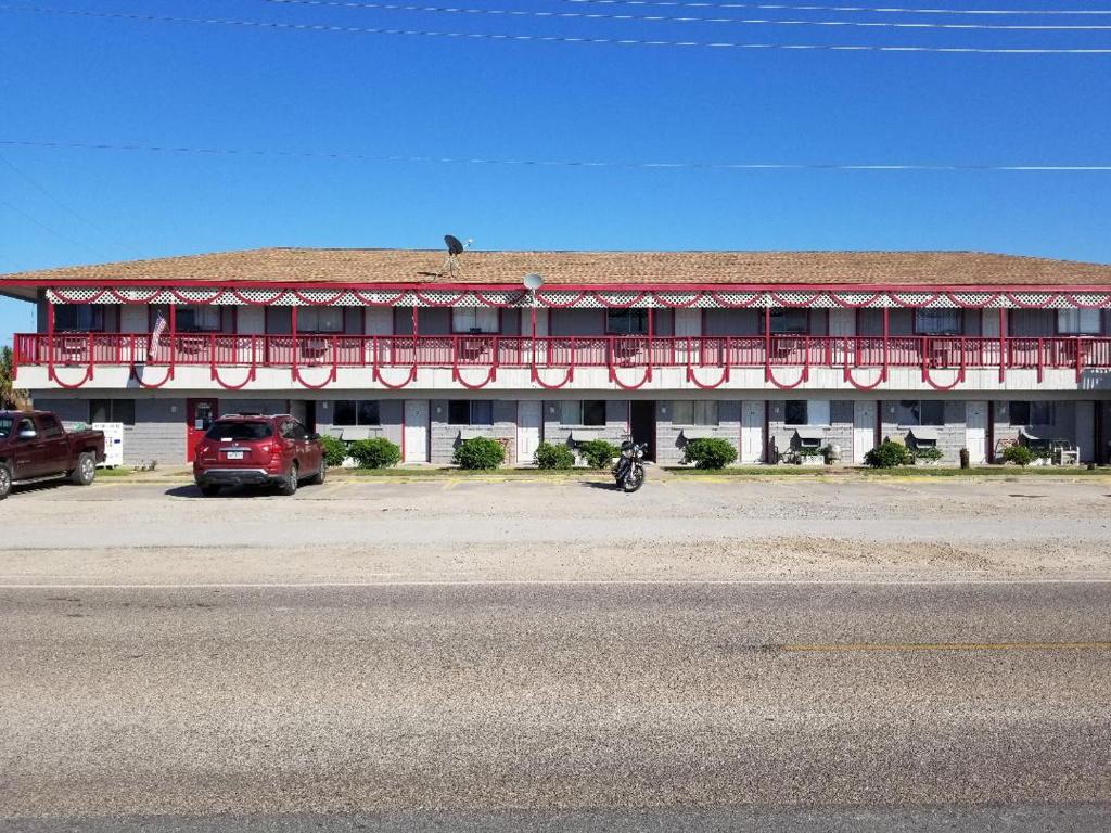 ein rotes und weißes Gebäude mit einem roten Balkon in der Unterkunft Anchor Motel & RV Park in Surfside Beach