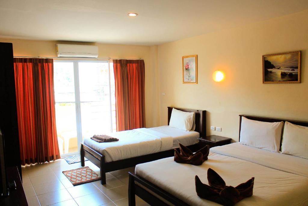 a hotel room with two beds and a window at Number 1 Guesthouse in Ao Nang Beach