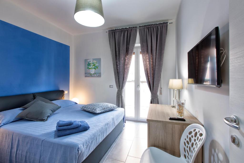 a blue bedroom with a bed and a window at B&B Civico 1 in Pavia