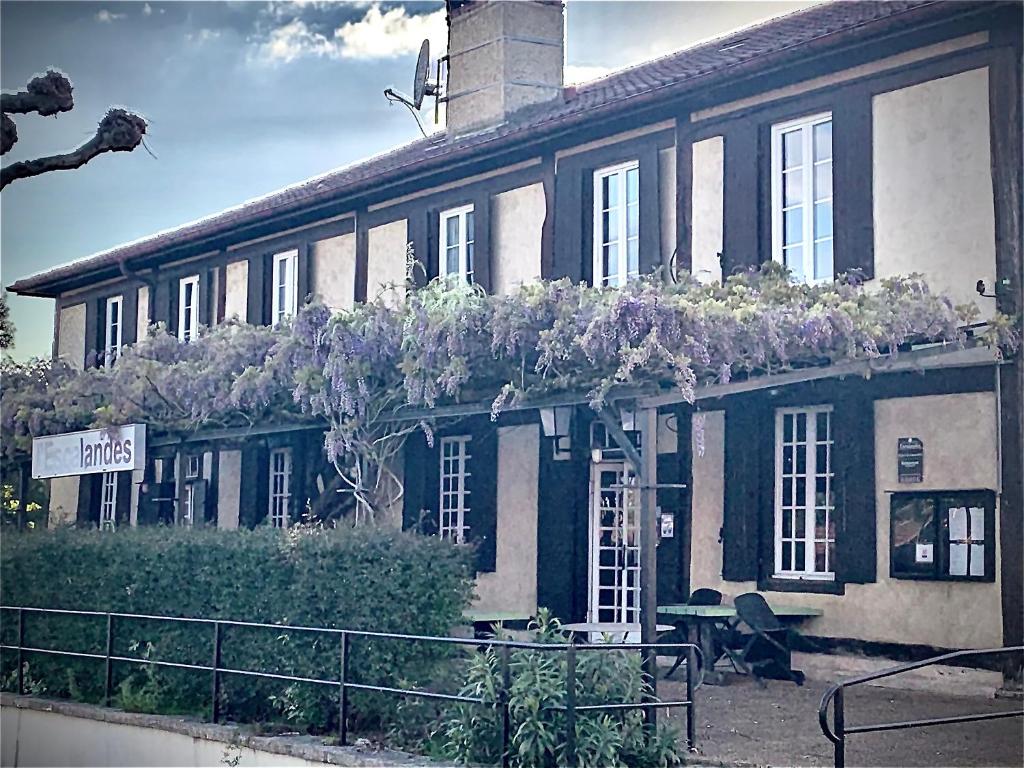 un edificio con flores a un lado. en Hôtel et RESTAURANT traditionnel L' Escalandes en Lesperon
