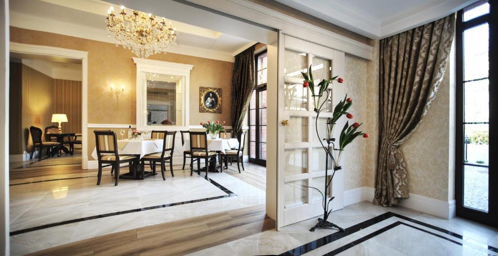 a dining room with a table and chairs and a chandelier at Hotel Kopernik in Ciechocinek