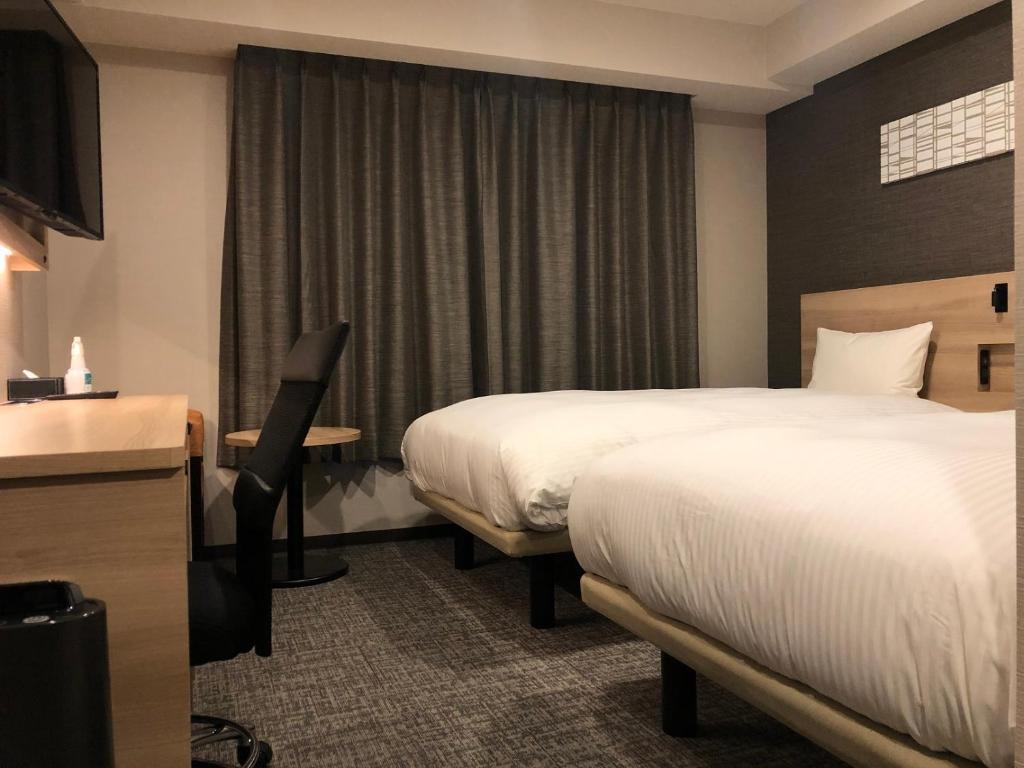 Postel nebo postele na pokoji v ubytování Smile Hotel Osaka Nakanoshima