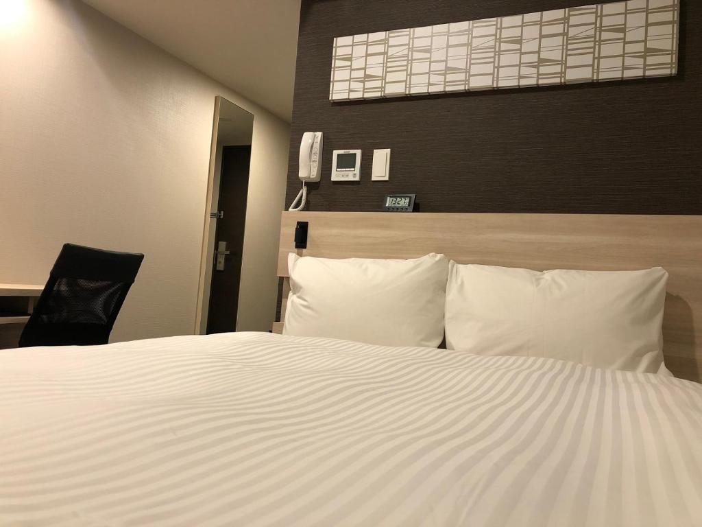Postel nebo postele na pokoji v ubytování Smile Hotel Osaka Nakanoshima