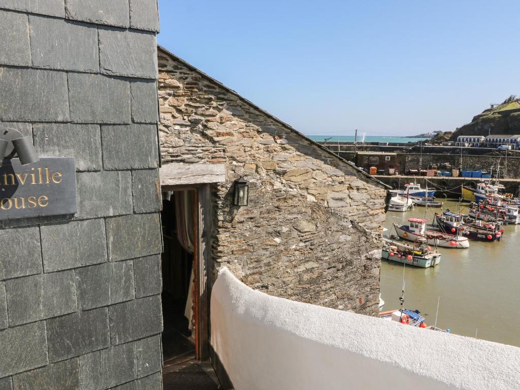 a stone building with boats in a harbor at Glanville House in Mevagissey