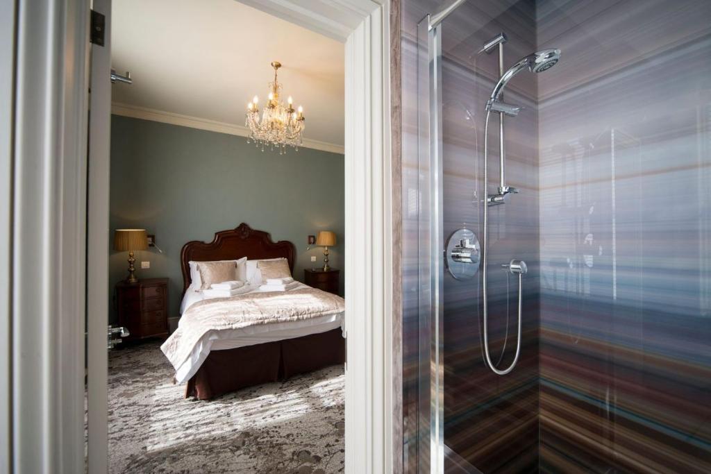 a bedroom with a bed and a glass shower at East Walls Hotel in Chichester