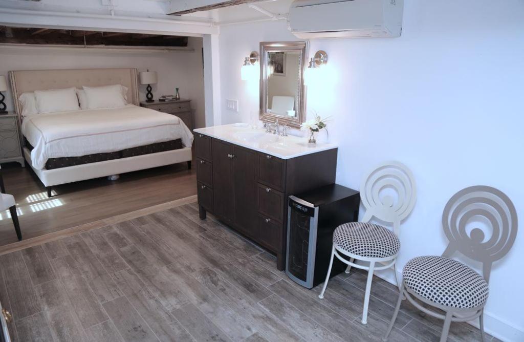a bedroom with a bed and a sink and two chairs at Harpoon House in Southampton