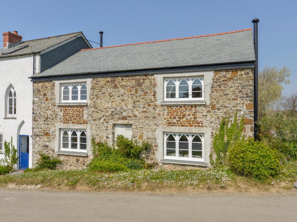 a brick house with white windows on a street at Chapel Cottage in Bideford