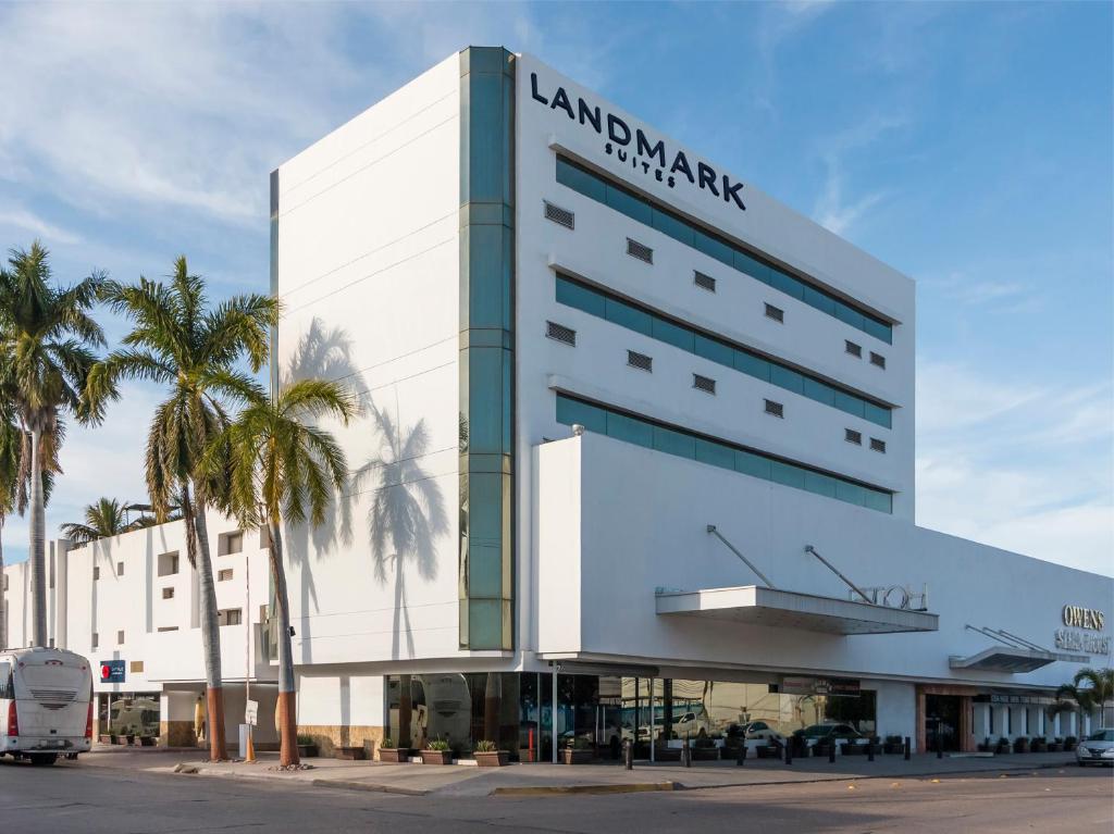 a large white building with a sign on it at Landmark Suites in Los Mochis