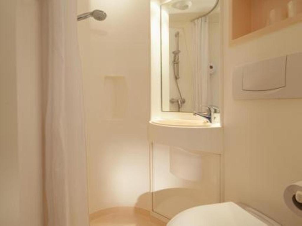a bathroom with a shower and a toilet and a sink at Premiere Classe Lille Sud - Douai Cuincy in Cuincy