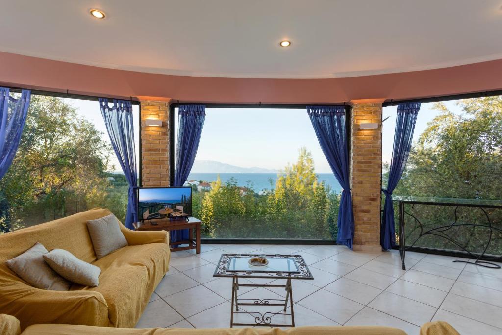 a living room with a couch and large windows at One Bedroom Villa in Alikanas