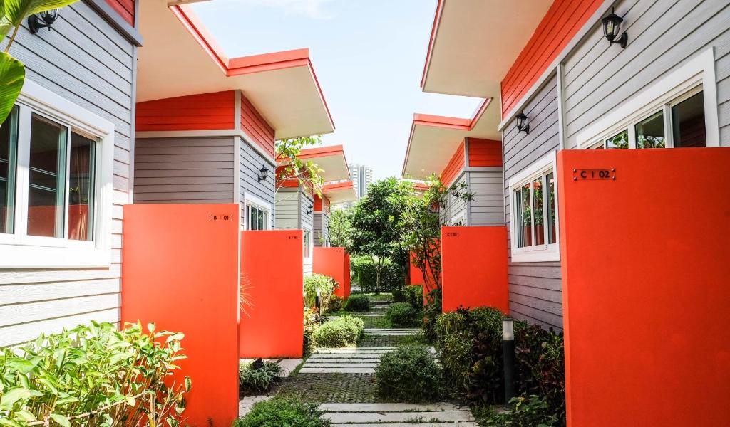 a row of houses with orange dividers in front at โรงแรมบ้านเพิ่มสุข อิมแพ็ค เมืองทอง in Pak Kret