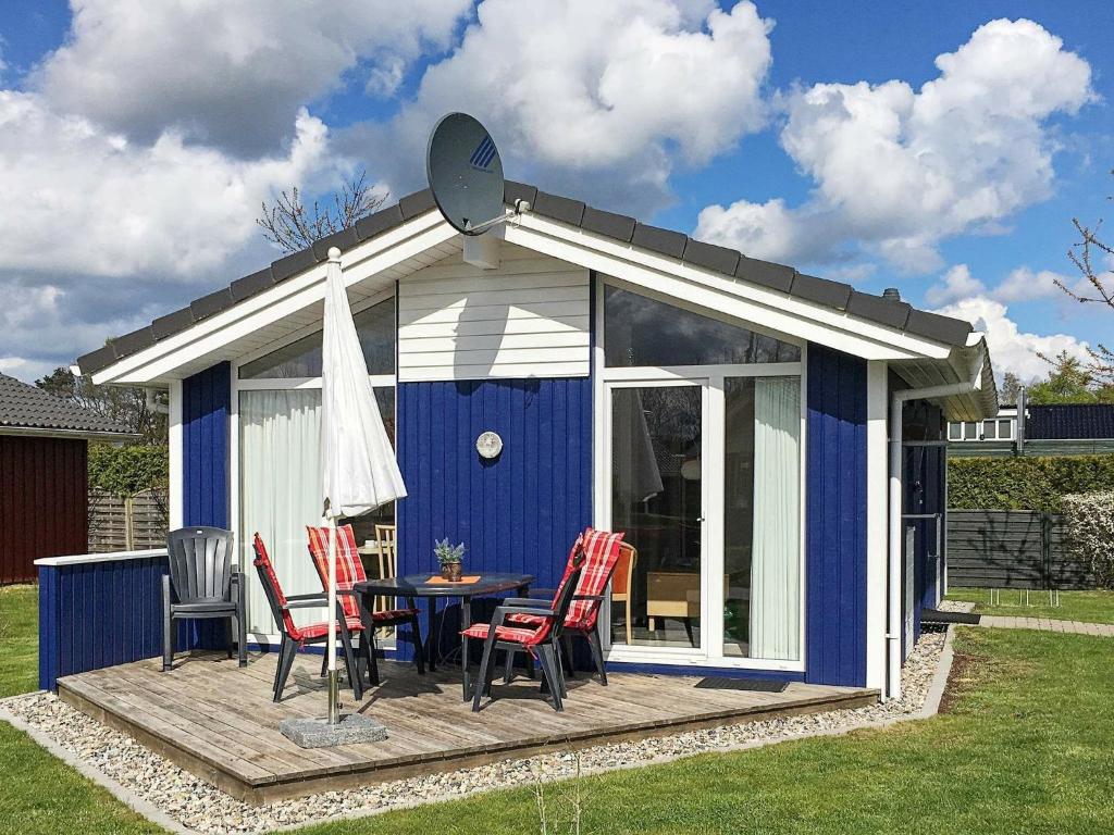 cobertizo azul y blanco con mesa y sillas en 4 person holiday home in GROEMITZ, en Grömitz